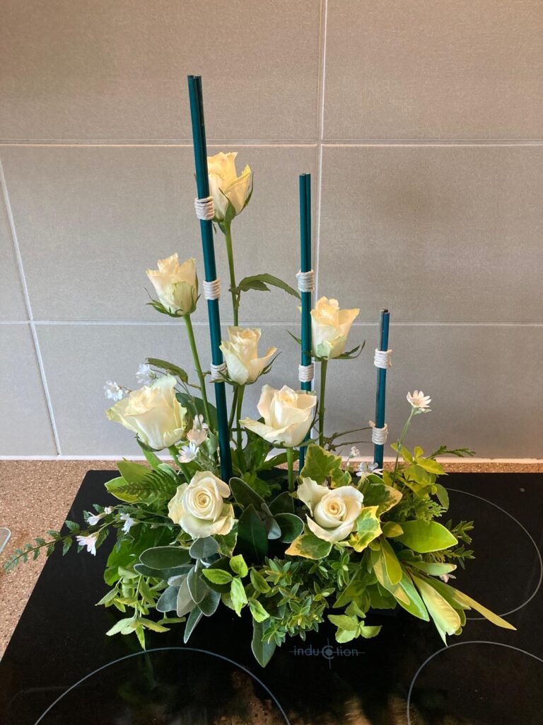 arrangement using sticks and white roses